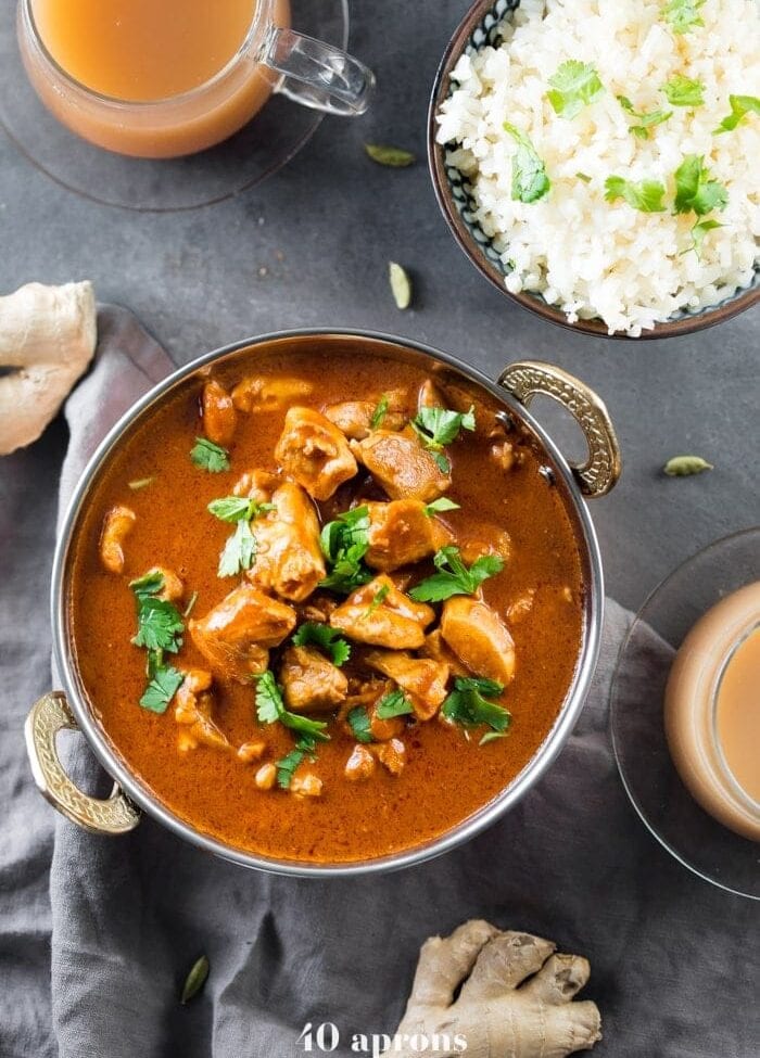 Indian butter chicken in a bowl with cauliflower rice and chai tea