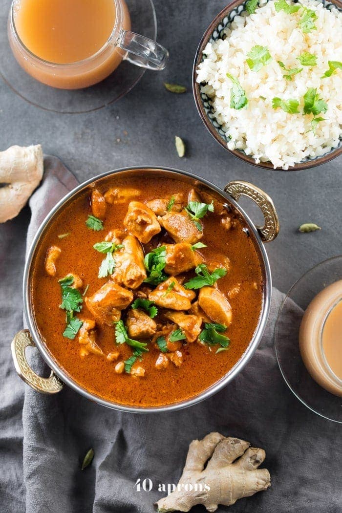 Indian butter chicken in a bowl with cauliflower rice and chai tea