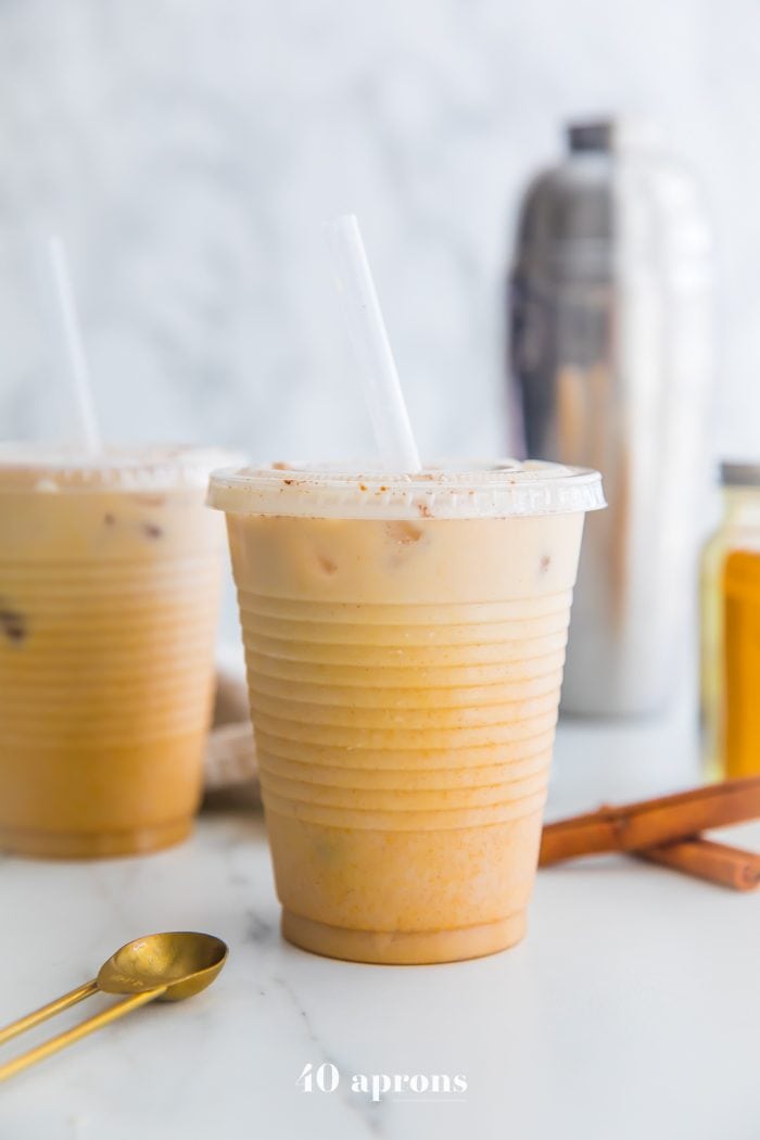 Iced golden milk turmeric latte in plastic cups with straws