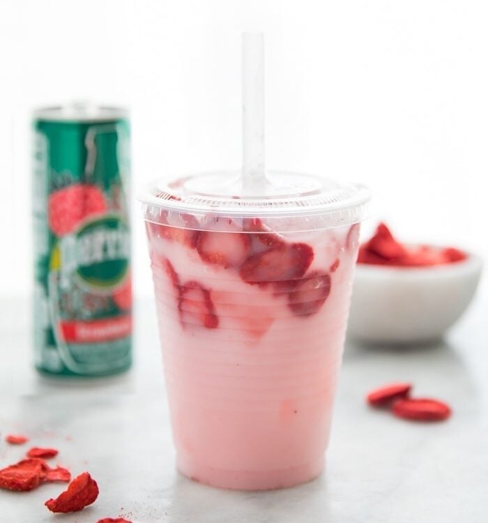 Healthy pink drink strawberry refresher with freeze dried strawberries, Perrier strawberry sparkling water, and coconut milk