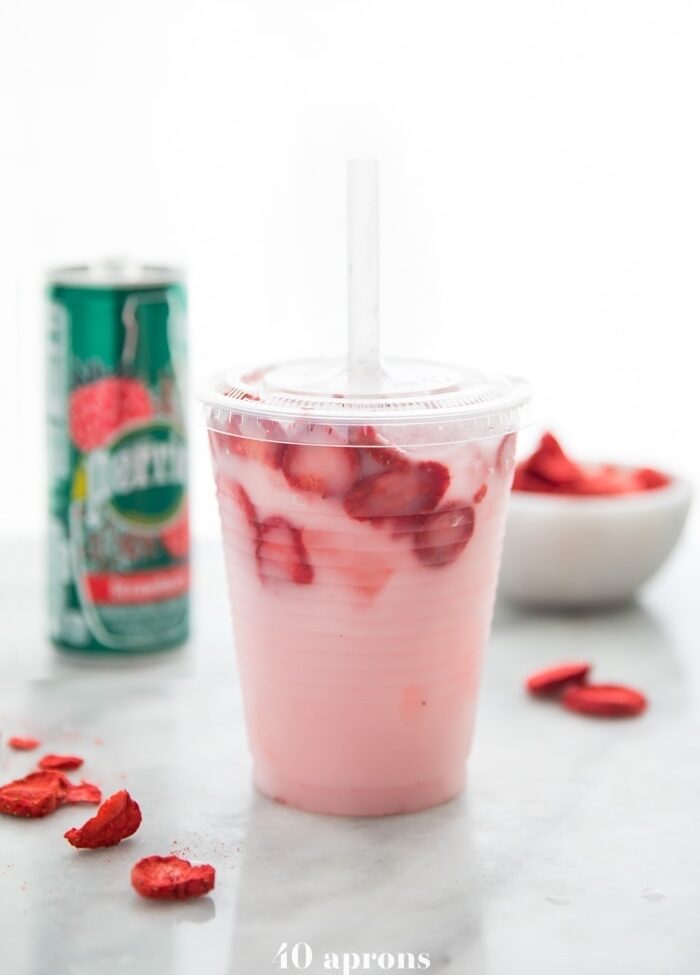 Healthy pink drink strawberry refresher with freeze dried strawberries, Perrier strawberry sparkling water, and coconut milk