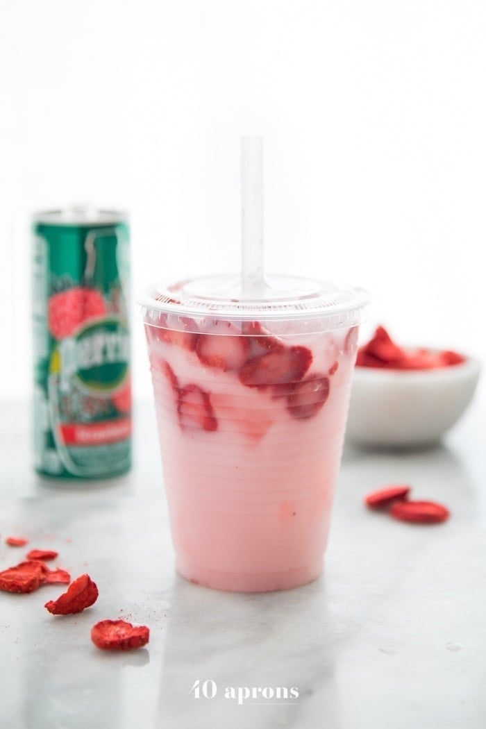 Healthy pink drink strawberry refresher with freeze dried strawberries, Perrier strawberry sparkling water, and coconut milk