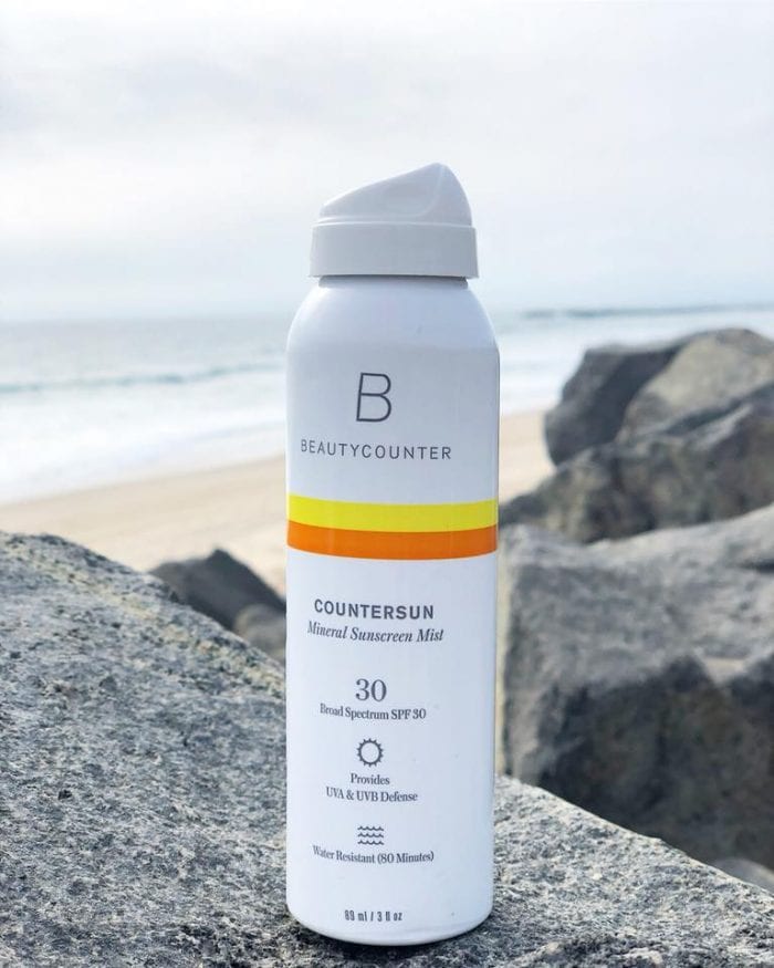 Beautycounter Countersun Mist (6-Ounce) on rocks overlooking the beach