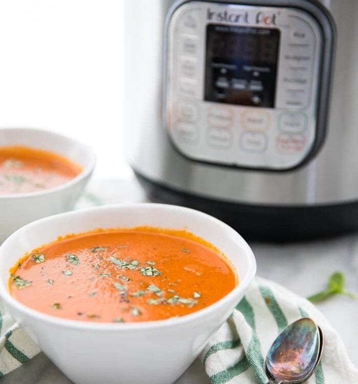 Perfect Whole30 Instant Pot tomato soup (vegan) in two bowls in front of the Instant Pot