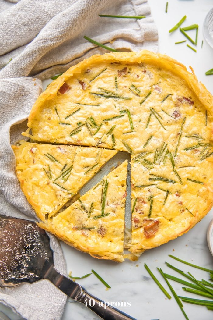 Whole30 quiche lorraine with hash brown crust slice with whole quiche in background