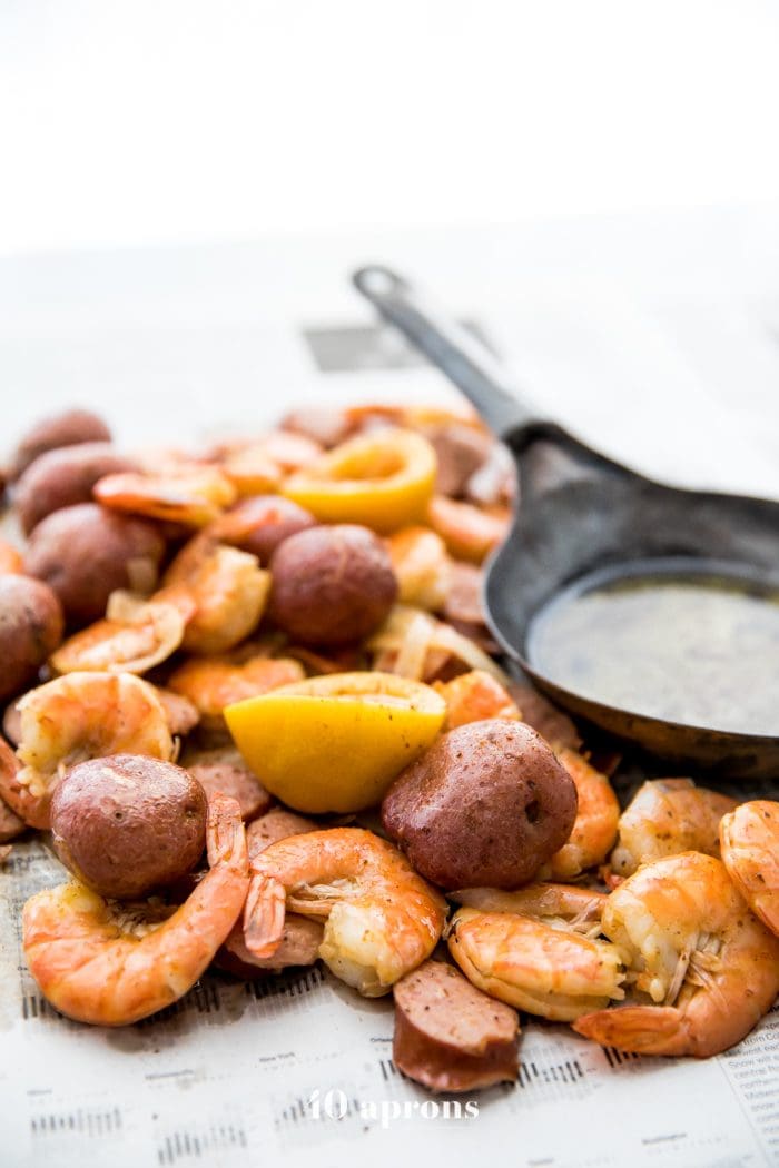 Whole30 shrimp boil with sausage, potatoes, and garlic ghee on newspaper