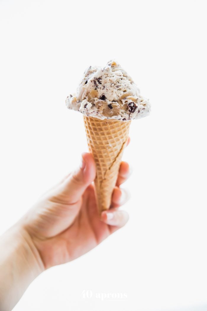 Hand holding a cone of paleo cookie dough ice cream