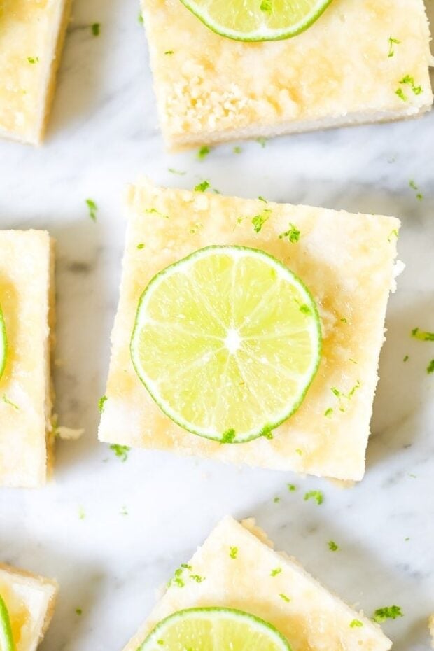Overhead shot of Paleo Lime Bars decorated with thin lime slices and placed on a marble counter top