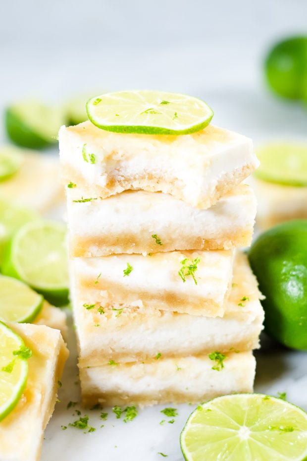 a stack of Paleo Lime Bars decorated with thin lime slices and placed on a marble counter top