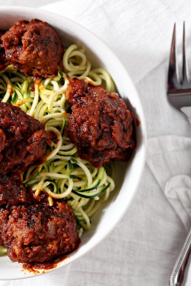 Overhead shot of Whole30 Spaghetti and Meatballs served over zucchini noodles in a white bowl