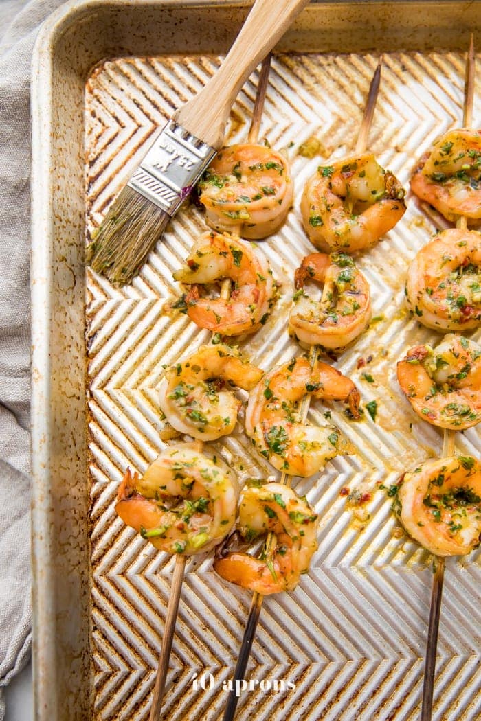 Easy Whole30 chimichurri shrimp skewers on a baking sheet