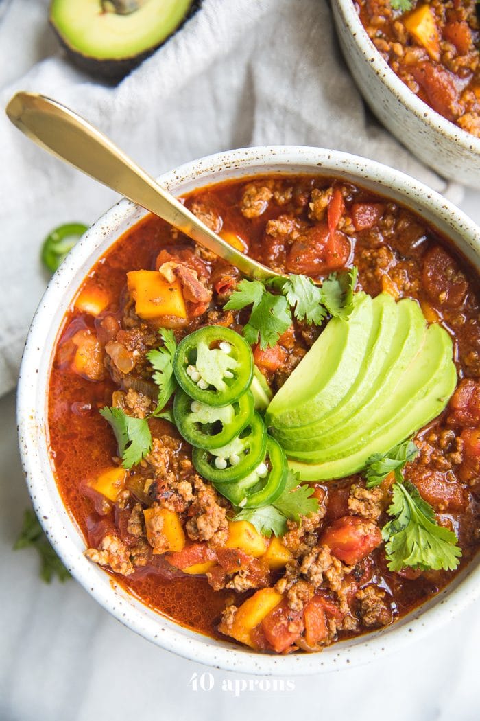 Bowl of Instant Pot Whole30 chili with butternut squash topped with jalapenos and avocados