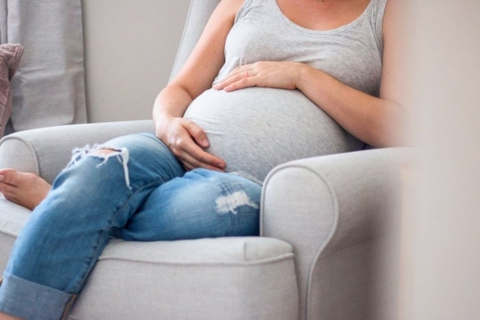 Pregnant woman sitting on nursery rocker
