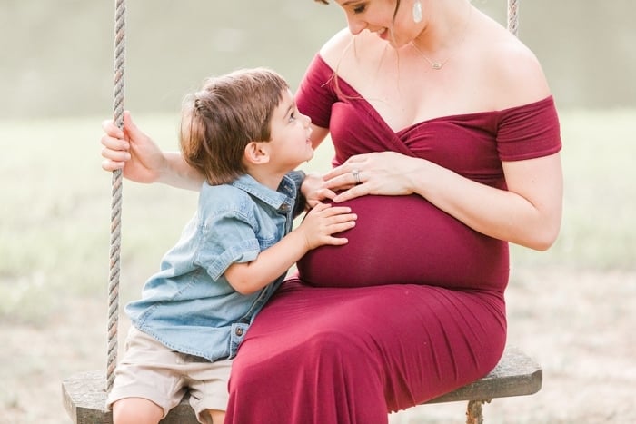 Toddler touching pregnant mom's belly