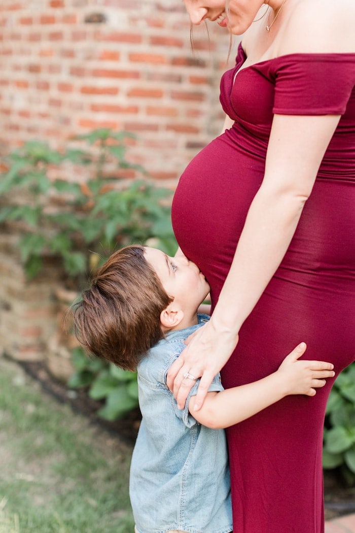 Toddler kissing pregnant mom's belly