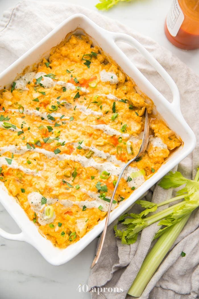 Paleo buffalo chicken casserole in a white dish with celery stalks to the side