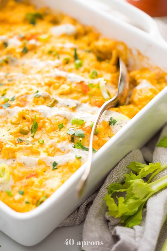 Paleo buffalo chicken casserole in a white dish with celery stalks to the side