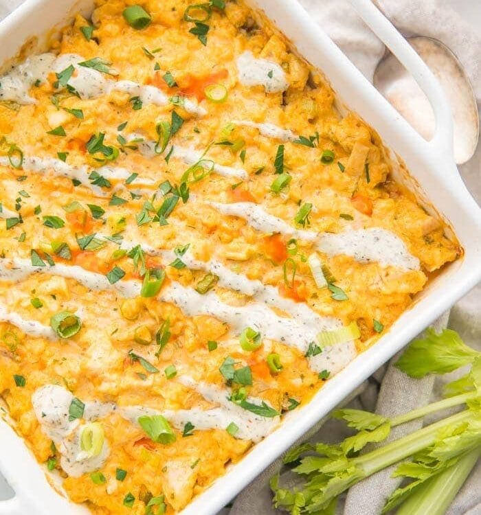 Paleo buffalo chicken casserole in a white dish with celery stalks to the side