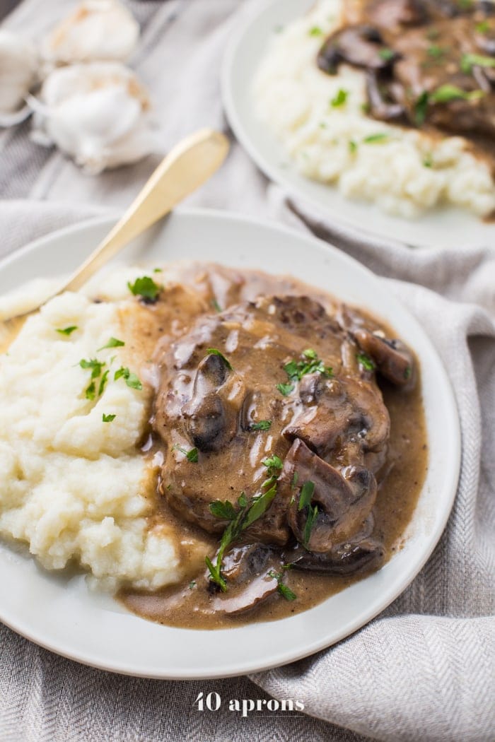 Whole30 Salisbury Steak bathed in a rich muhshroom gravy served with creamy mashed potatoes