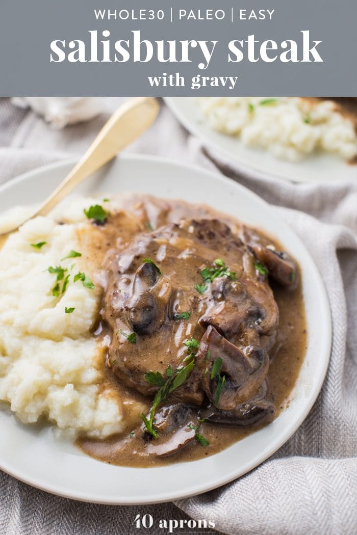 Close-up of Whole30 Salisbury Steak smothered with mushroom gravy with a side of creamy mashed potatoes.