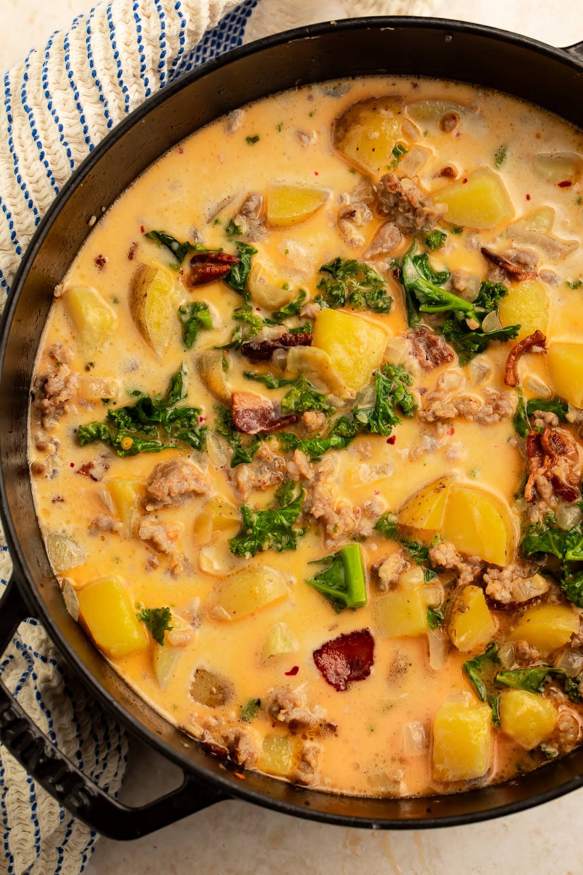Close up of zuppa toscana in a cast iron cooking pot.