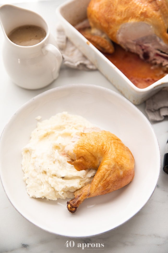 Best easy roast chicken cut into leg and thigh over mashed potatoes