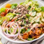 Whole30 loaded burger bowls with ground beef, red onions, bacon, pickles, guacamole, and tomatoes
