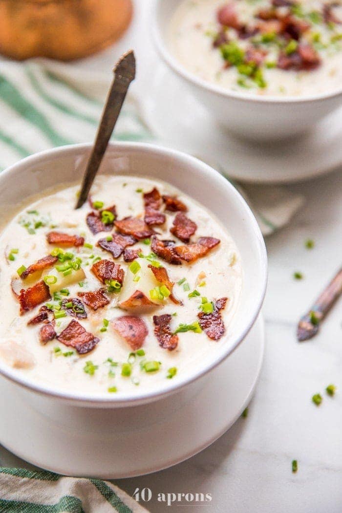 Close up of healthy creamy Whole30 clam chowder in two bowls with bacon and chives