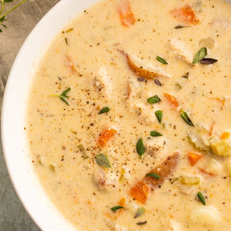 A white soup bowl, holding a creamy chicken pot pie soup made in the Instant Pot.