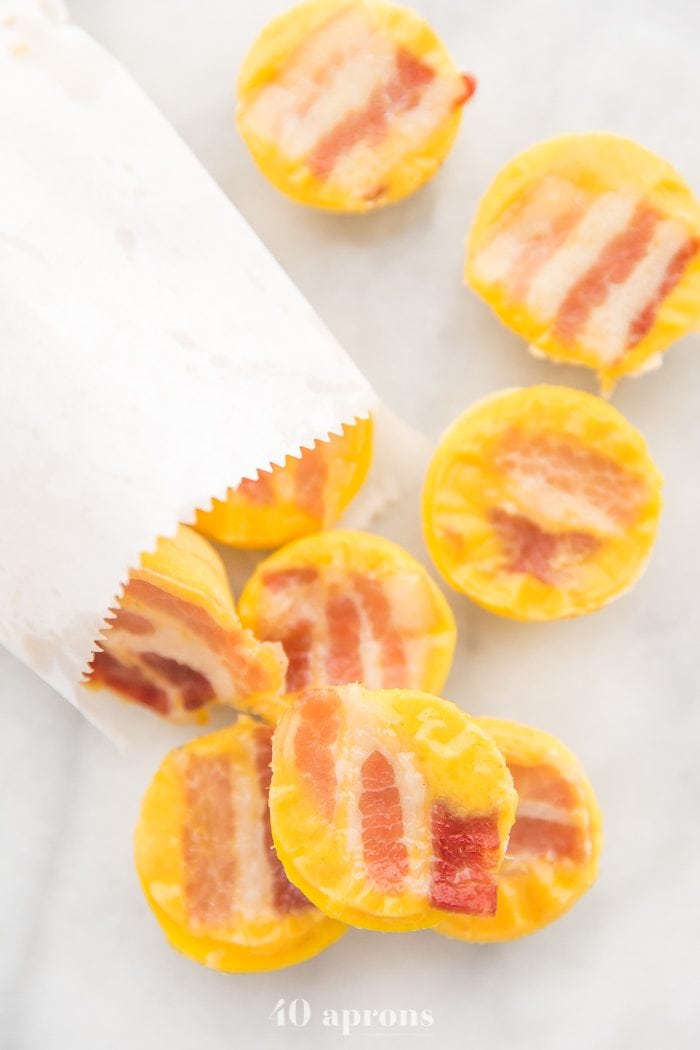 Healthy sous vide egg bites with bacon coming out of a white paper bag