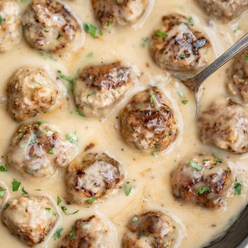 Whole30 Swedish meatballs in a large cast-iron skillet with plenty of creamy sauce.