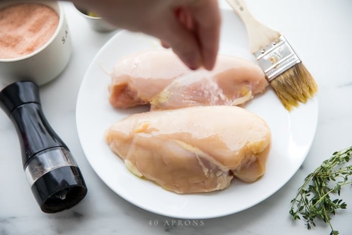 Season chicken breasts with salt