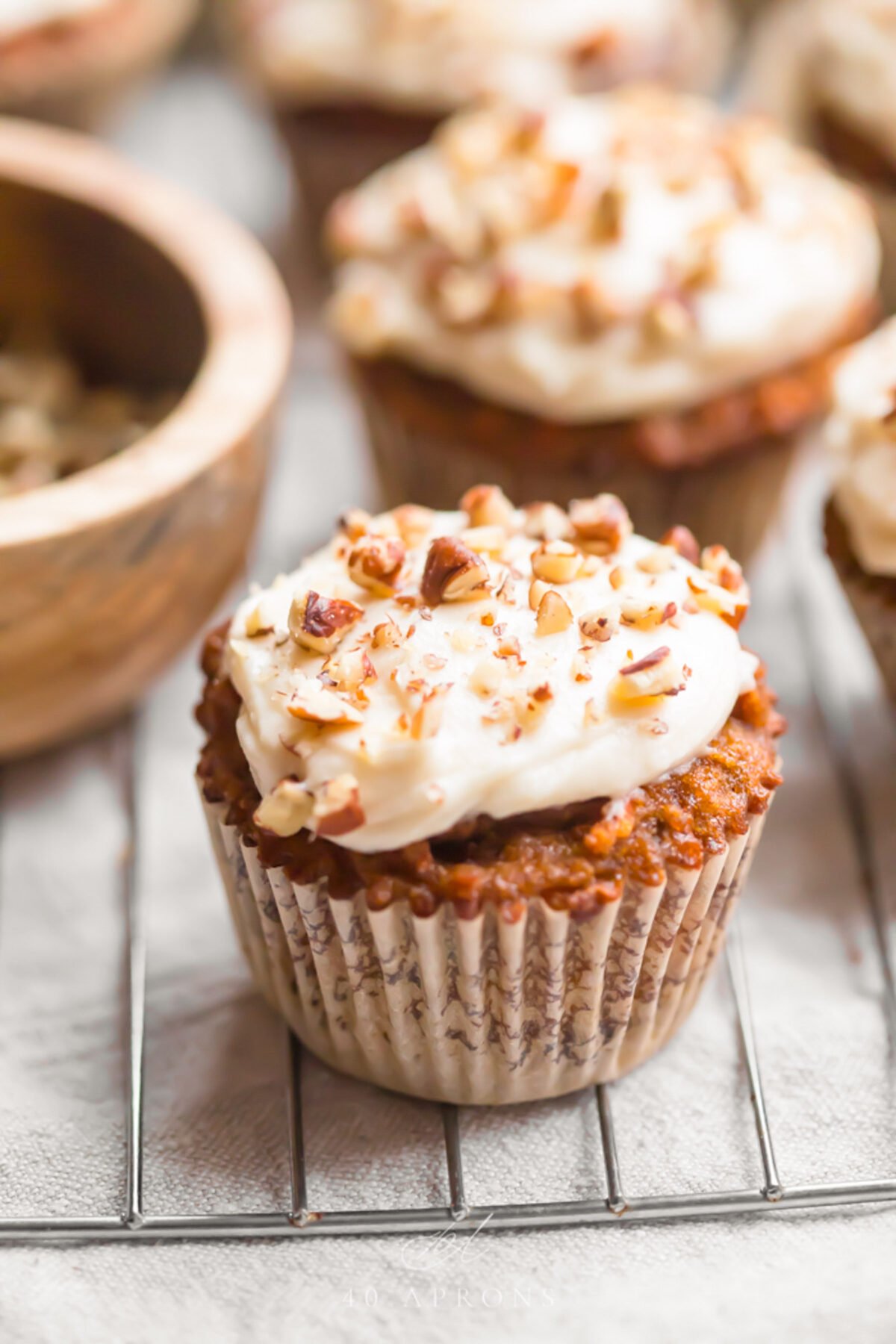 Paleo carrot cake cupcakes with cream cheese frosting on a wire cooling rack.
