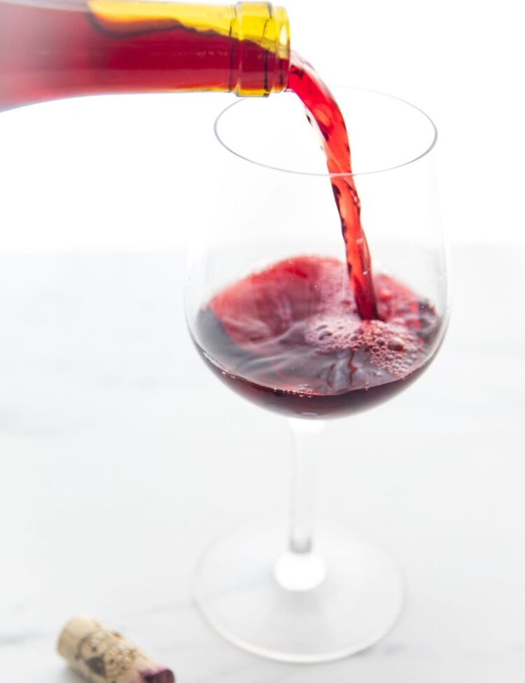 Glass of organic red wine being poured into a wine glass