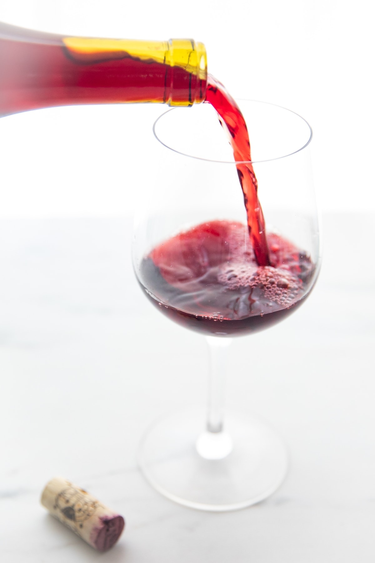 Glass of organic red wine being poured into a wine glass