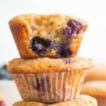 Blueberry muffins stacked with a bite out of one