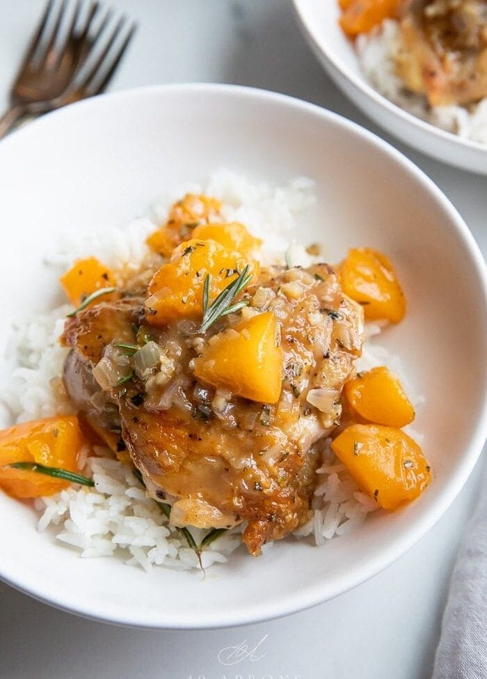 Apricot chicken over white rice in a white bowl