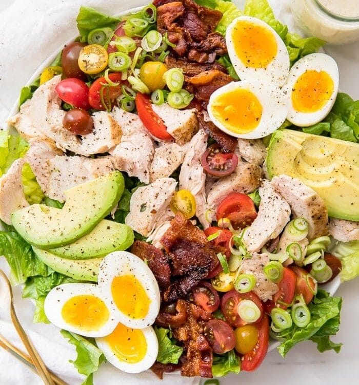 A classic healthy chicken cobb salad on a white plate