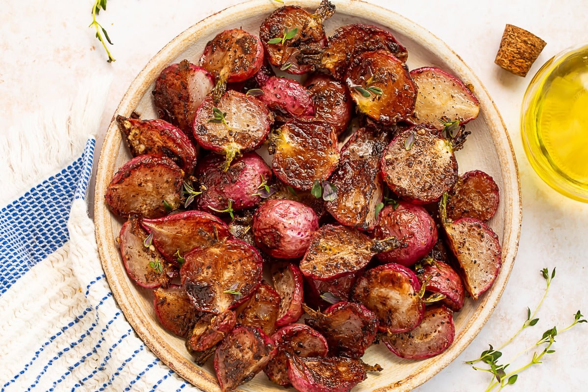 A plate of roasted radishes drenched in garlic browned butter.