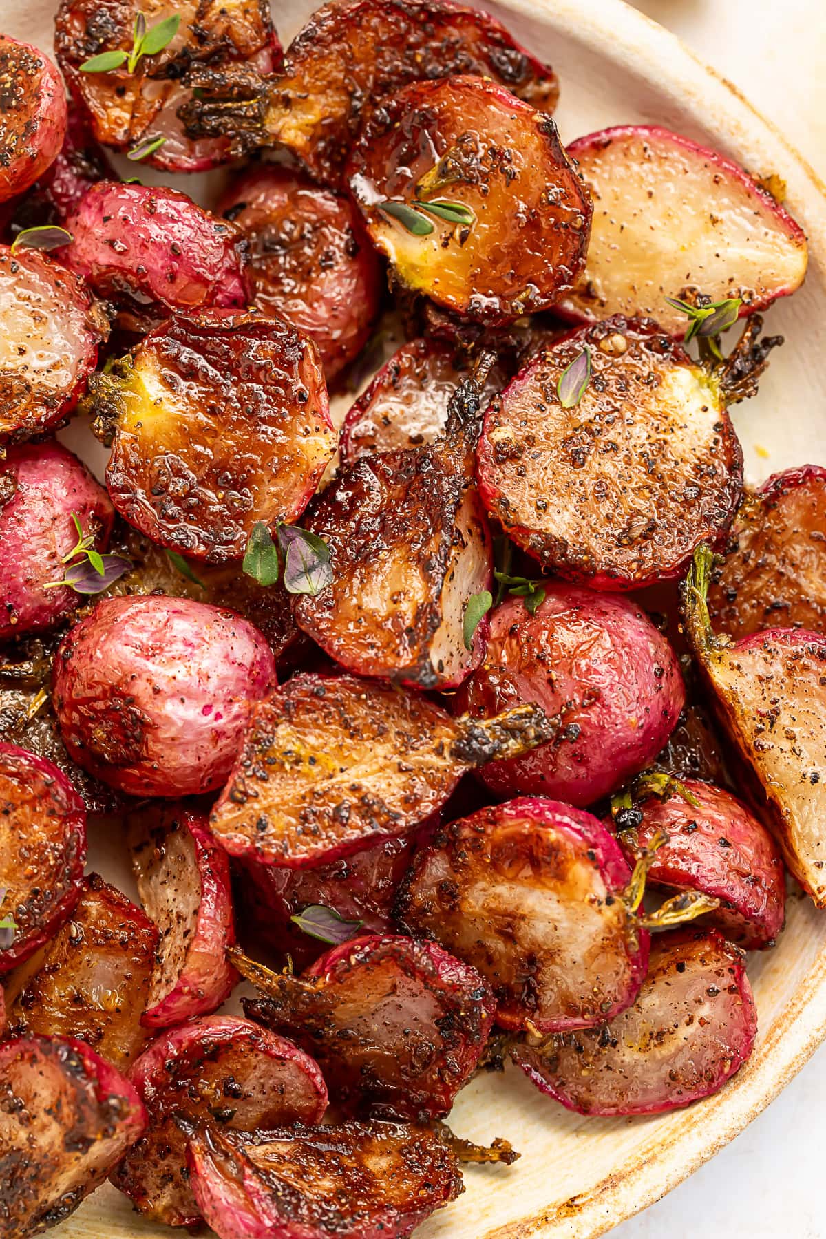 Close-up of a plate of roasted radishes drenched in garlic browned butter.