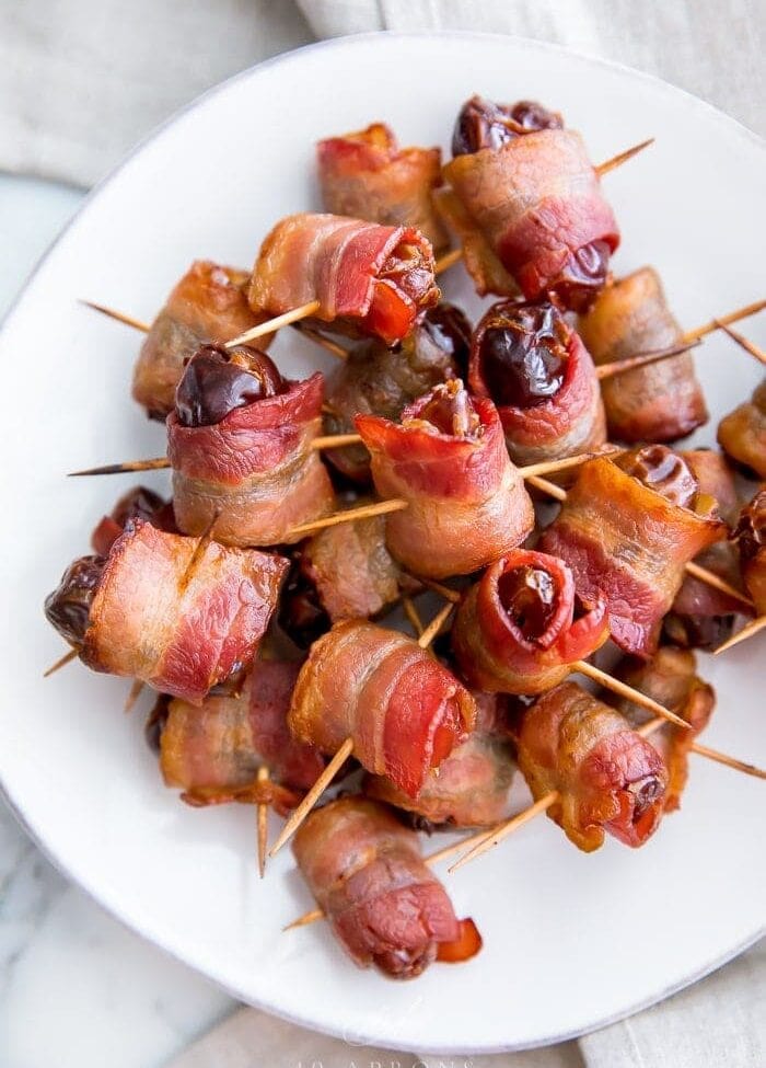 Bacon wrapped dates on a white plate