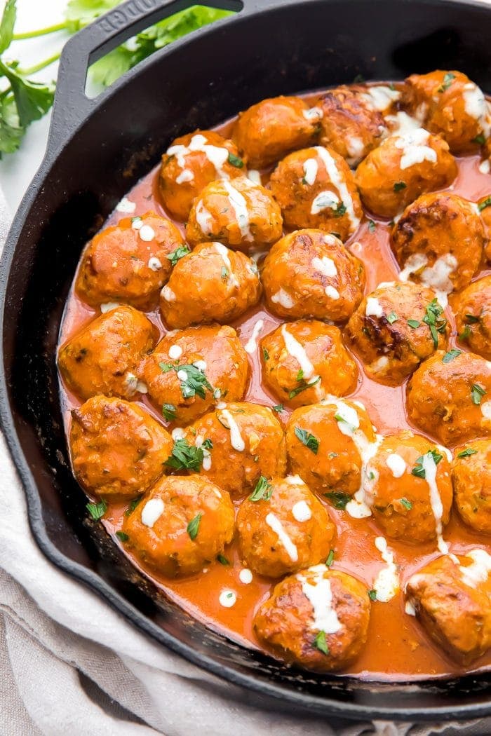 Meatballs in a skillet with ranch dressing drizzled over them