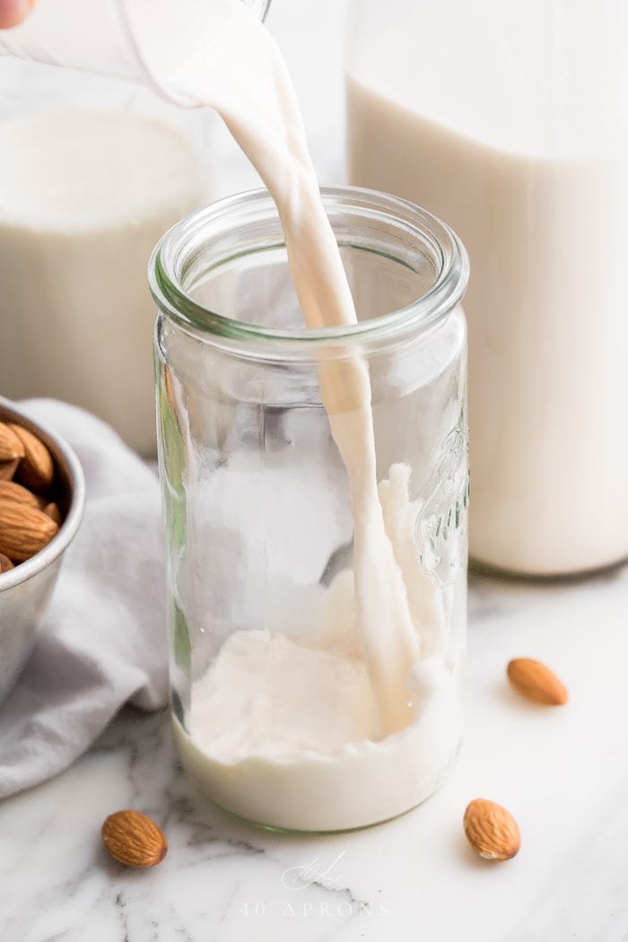 Homemade almond milk pouring into a jaar