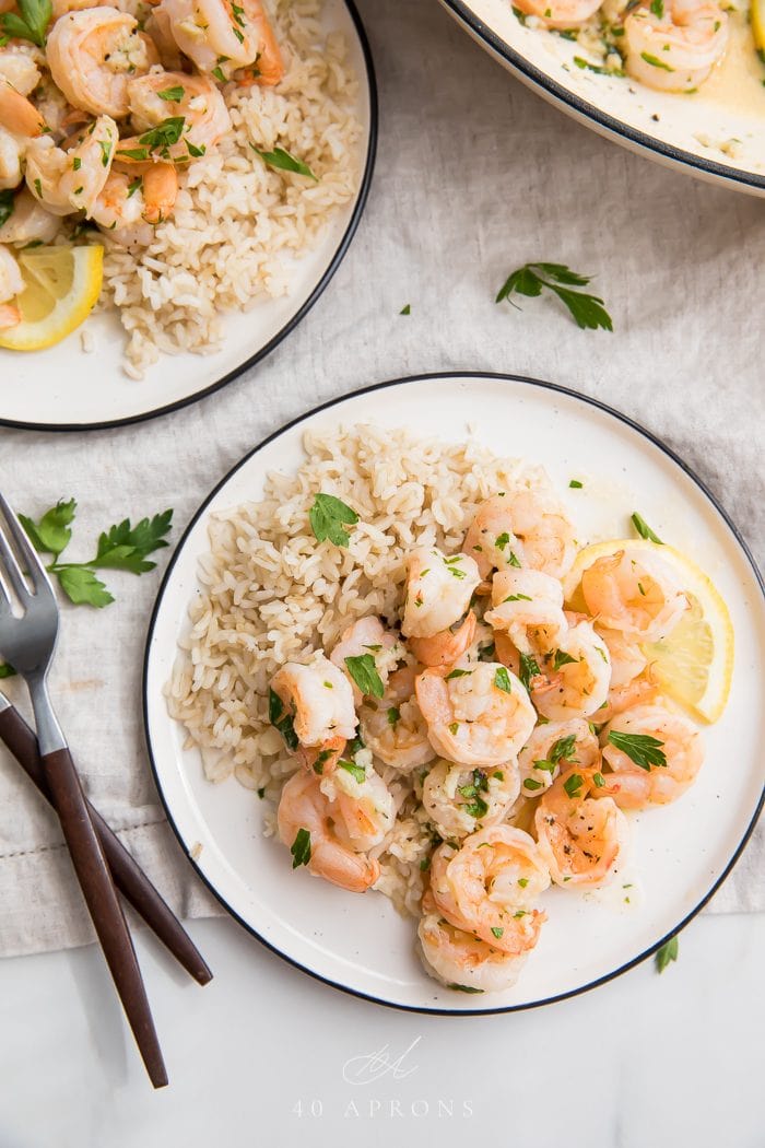 Two plates of lemon garlic shrimp with brown rice