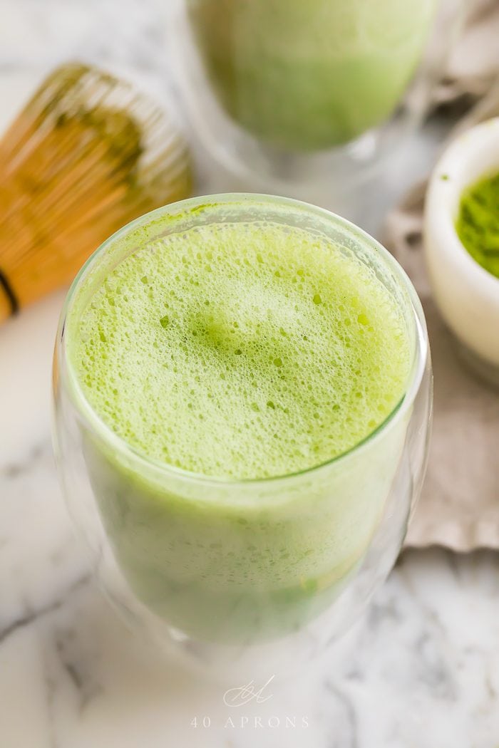 A freshly made green drink with a foamy top