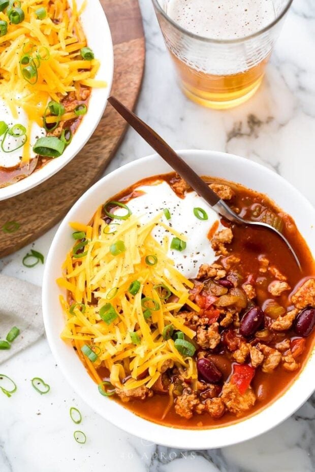 Turkey chili served in a white bowl with toppings