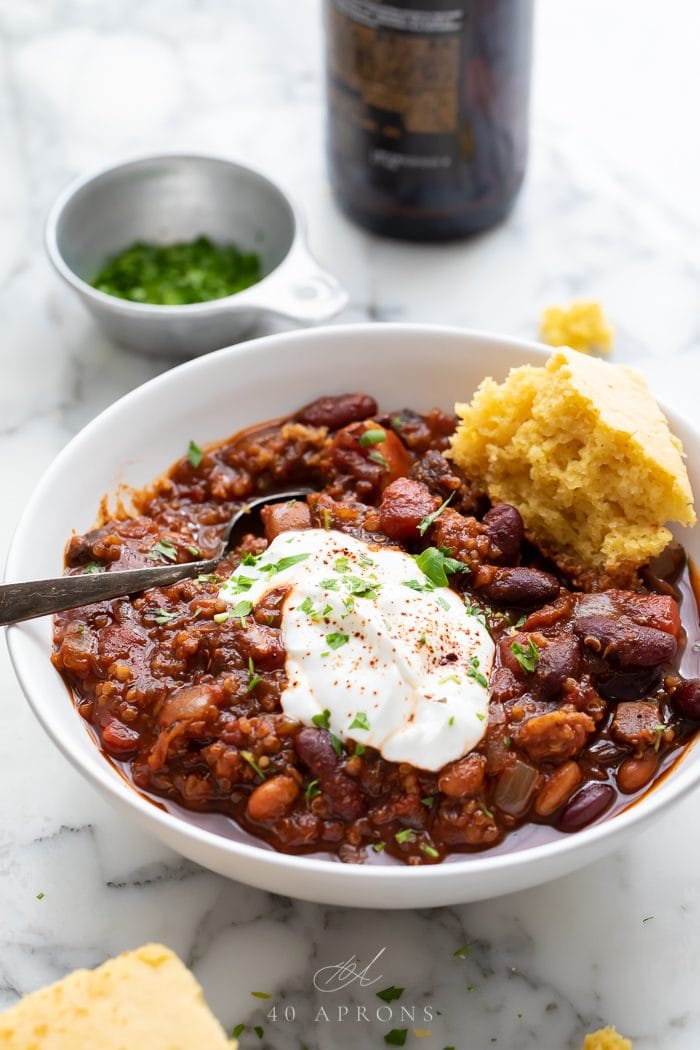 Vegan chili served in a white bowl with toppings