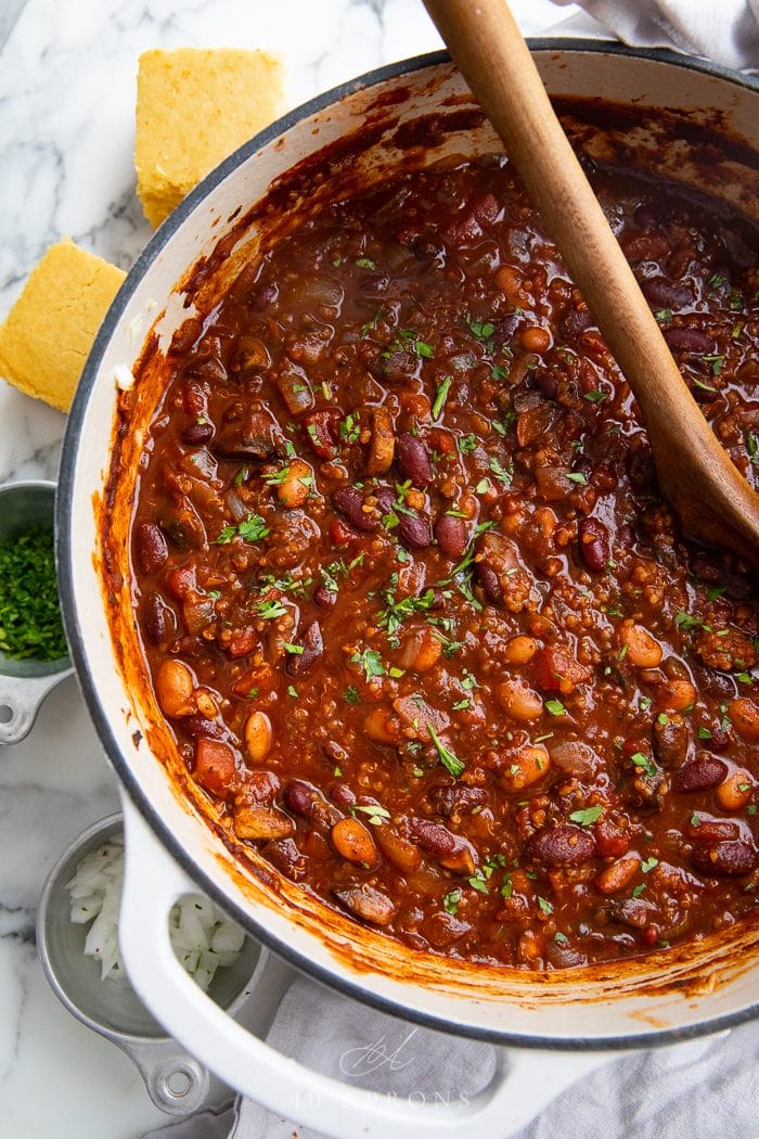 Vagan chili in a pot with a wooden spoon