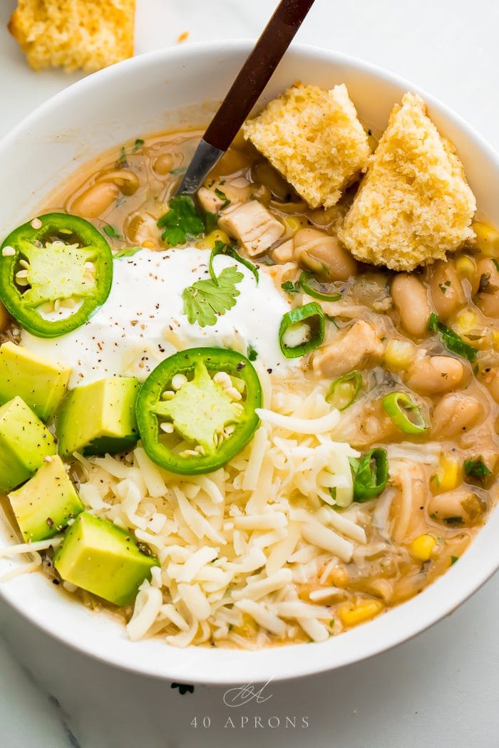 White bean chili served with toppings in a white bowl