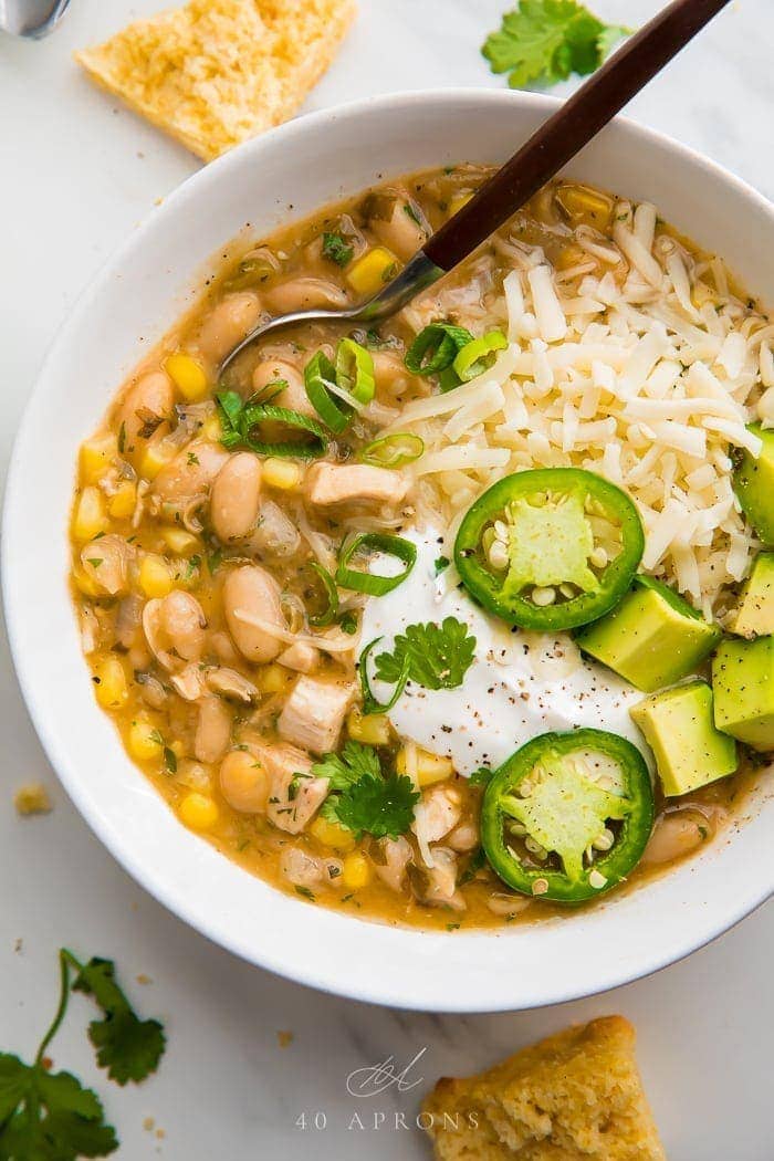 white bean chili in a white bowl with fresh toppings